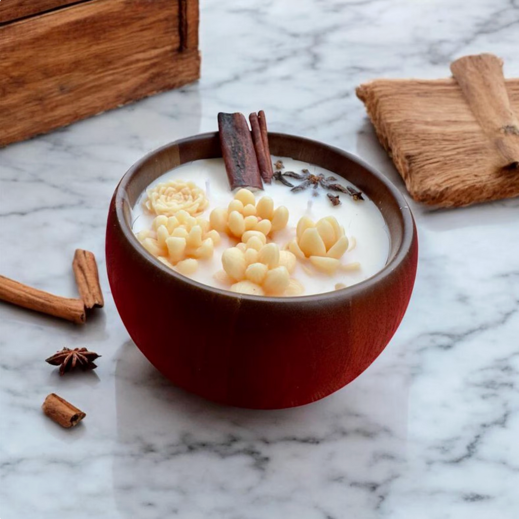 Candle in a brown bowl with cream-colored flower decorations